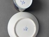 pair of white and blue porcelain plates with blue writing on them