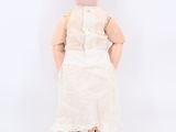 a small doll with a white dress and a pink hat