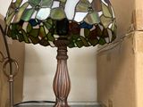 a lamp that is sitting on a shelf next to a lamp