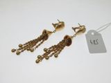 a pair of gold tone earrings with dangling chains