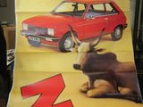 Quelqu'un tient une grande affiche représentant une voiture et une vache.