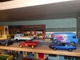 de nombreuses petites voitures et camions sur une étagère dans une pièce