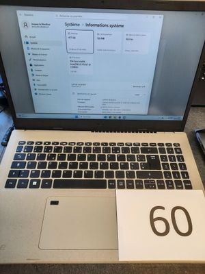 un ordinateur portable posé sur un bureau, à côté d'un bloc-notes