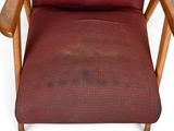 a red chair with a wooden arm rest and a red cushion