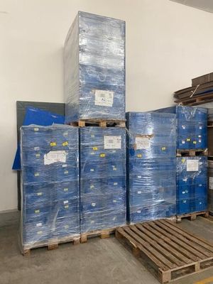 de nombreuses palettes de cartons empilés les uns sur les autres dans un entrepôt