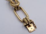 a close up of a gold chain with a padlock on it