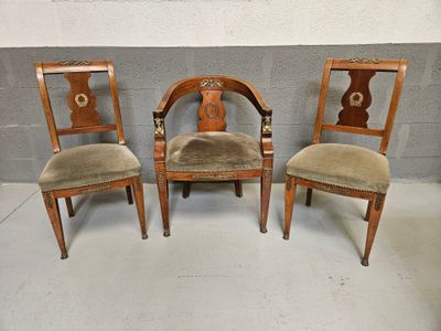 three wooden chairs with velvet upholstered seats sit in front of a brick wall
