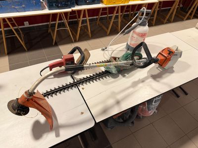 un petit pot de fleurs posé sur une table, avec une bouteille d'eau à côté