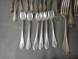a lot of forks and spoons that are on the table