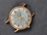 a gold watch with roman numerals on the face