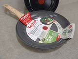 a frying pan with a spatula in it on the floor