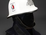 white hard hat with a crest on the front and a black hat on the back