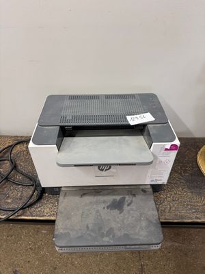 une imprimante posée sur une table, à côté d'une lampe