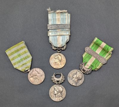 three medals and a medal on a gray surface