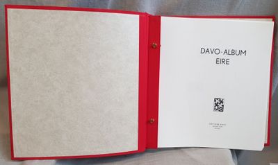 a book with a red cover sitting on top of a bed
