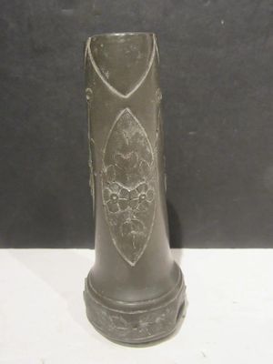 a black vase with a design on it sitting on a table