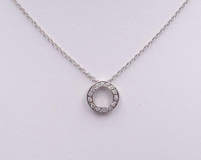 un collier en or blanc orné d'un cercle de diamants suspendu à une chaîne