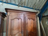 a wooden cabinet with a door and a mirror on top of it