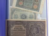 deux vieux billets de banque posés sur une table, à côté d'un rouleau de papier bleu