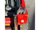 a red skid steer that is attached to a fork