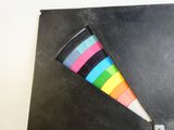 a piece of black paper with colored tape sticking out of it