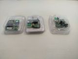 three electronic devices in plastic containers on a table