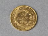 a close up of a gold coin on a white surface