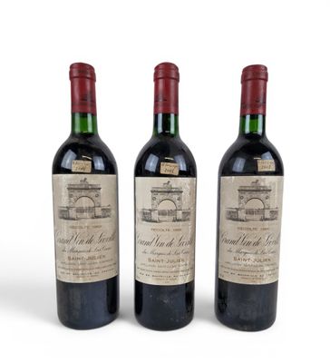 three bottles of wine are lined up on a white surface