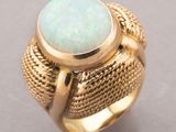 a close up of a gold ring with a white oplite in it