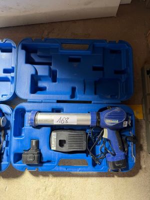 une mallette bleue contenant des outils, posée par terre