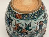 a vase with a painting on it sitting on a table