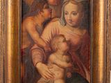 un vieux tableau représentant une femme tenant un bébé dans ses bras, dans un cadre en bois