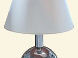 une lampe de table argentée avec un abat-jour blanc