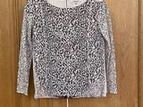 un pull noir et blanc accroché à une porte en bois