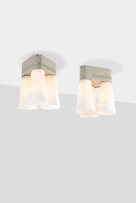 three light bathroom fixture with white glass shades on a gray wall