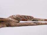 a close up of a wooden sculpture of a person holding a pair of scissors