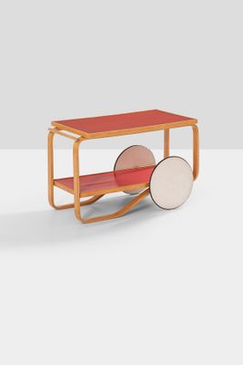 a red table with wheels and a wooden shelf on top