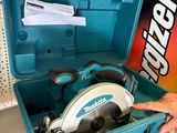 une personne tenant une scie circulaire dans une boîte à outils
