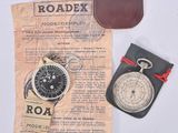 a pocket watch and a leather wallet on a table