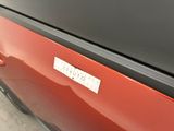 a close up of a red car with a sticker on it