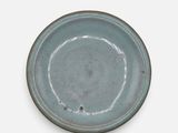 une assiette bleue posée sur une table blanche, sur fond blanc