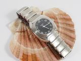a watch sitting on top of a shell on a white surface