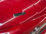 a close up of a shiny red car with a chrome emblem