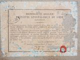 a plaque on the side of a building with a red stamp on it