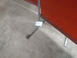 une table rouge sur laquelle est posée une étiquette blanche