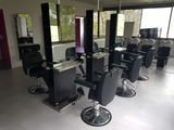 many chairs in a room with mirrors on the walls