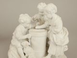 a white statue of two children playing with a bucket