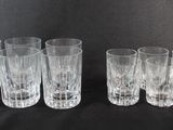 six verres transparents alignés sur un fond noir