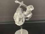 une figurine en verre représentant un oiseau et une fleur posée sur une table