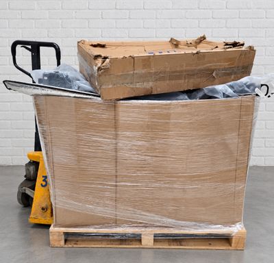 a pallet full of boxes sitting on the floor next to a hand truck
